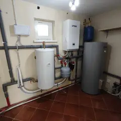 Instalacja grzewcza z pompą ciepła. Widoczny zasobnik wody, zbiornik wyrównawczy i sterownik. Sprawdzamy jakie ciśnienie w pompie ciepła jest optymalne.