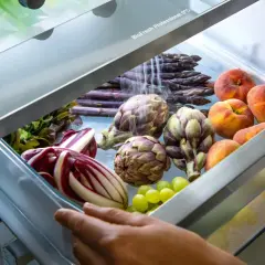 Asparagi viola, carciofi, pesche e uva in un cassetto del frigorifero. Ecco come conservare gli asparagi freschi e altri ortaggi.