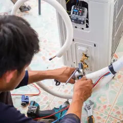 Technik montuje jednostkę klimatyzacyjną, dbając o prawidłowe odprowadzenie skroplin z klimatyzacji.