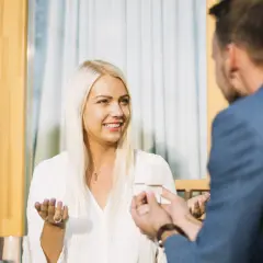 Uśmiechnięta blondynka słucha mężczyzny, który trzyma pudełko. Czy to moment, jak zapytać dziewczynę o związek?