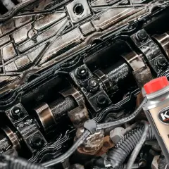Wnętrze silnika po płukaniu ropą. Widać zabrudzone elementy i butelkę preparatu K2 Motor Flush.