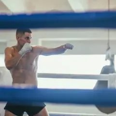 A boxer throws punches in a ring, practicing his moves. This is how shadow boxing, a training technique, likely began.