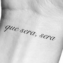 Tatuaż na nadgarstku z napisem "que sera, sera", co oznacza "co ma być, będzie".