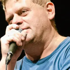 Kazik Staszewski śpiewa, trzymając mikrofon. Jego utwory to klasyka polskiego rocka.