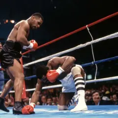 Mike Tyson lands a powerful punch, sending his opponent to the canvas. A classic example of the best Mike Tyson knockouts.
