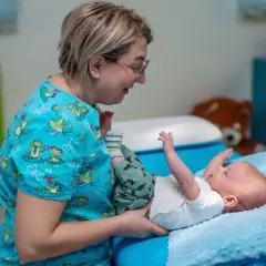 Terapeuta pomaga dziecku z problemem refluksu ukrytego, wykonując delikatne ćwiczenia.