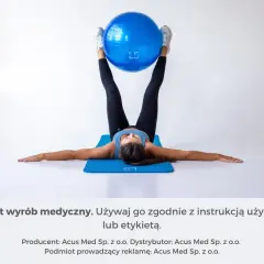 Kobieta ćwiczy, trzymając piłkę nogami, wzmacniając mięsień biodrowo-lędźwiowy.