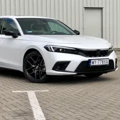 Biały Honda Civic 2025 z czarnymi felgami stoi na parkingu.