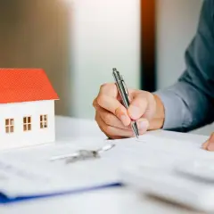 Firma contratto immobiliare: attenzione ai rischi nel vendere casa con agenzia. Modello casa, chiavi e firma su documento.