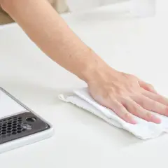 Mano limpiando una superficie blanca con un paño, como si fuera limpiar suelo de mármol.