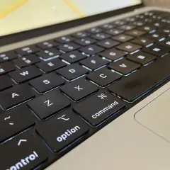Klawiatura laptopa z podświetlanymi klawiszami. Widoczne litery Q, W, E, A, S, D, Z, X, C, a także klawisze "control", "option" i "command".