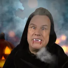 Ein Mann mit Vampirzähnen und blutigen Lippen, im Hintergrund eine leuchtende Kürbislaterne. Vielleicht die wahre Bedeutung von Halloween?