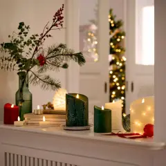 Gemütliche weihnachtsdeko tipps: Kerzen, Tannenzweige und Lichterketten schaffen festliche Stimmung.