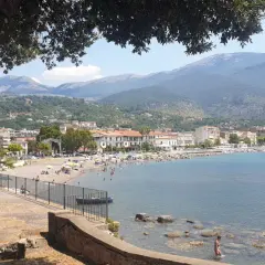 Vista panoramica di Sapri con la sua spiaggia affollata, il mare azzurro e le montagne sullo sfondo. Un luogo ideale per scoprire cosa vedere a Sapri.