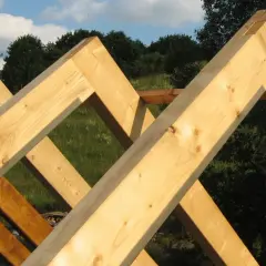 Drewniane krokwie połączone na zakładkę tworzą solidną konstrukcję dachu.