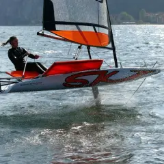 Vela da regata con foil che solleva lo scafo dall'acqua, creando un effetto simile a una falena in volo.