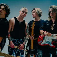 Czterech młodych mężczyzn z zespołu Felivers pozuje z gitarami i pałeczkami perkusyjnymi.