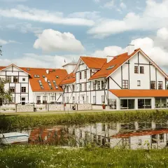 Malowniczy widok na narie resort & spa z łódką przy brzegu i odbiciem w wodzie.