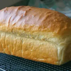 Pan de molde dorado y esponjoso enfriándose en una rejilla, perfecto para tus próximas recetas con pan de molde.