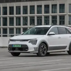 Białe Kia Niro stoi na parkingu. Sprawdź kia niro wymiary, by poznać jego kompaktowe gabaryty idealne do miasta.