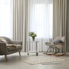 Elegantes tipos de cortinas para ventanas, con un sofá y mecedora en un salón moderno.