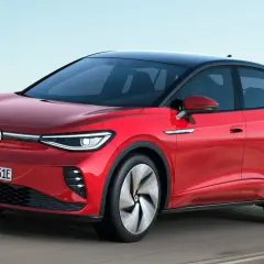 Czerwony VW ID.5 z czarnym dachem sunie po drodze, prezentując nowoczesny design i elektryczną moc.