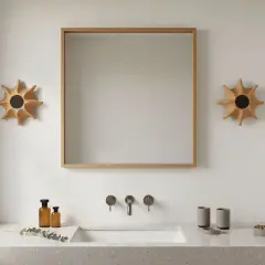 Un moderno aplique baño pared con forma de sol ilumina el espacio junto a un espejo de madera.