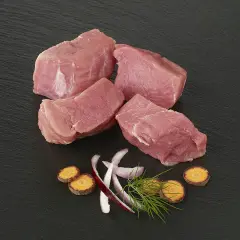 Quatre morceaux d'épaule de veau crus, accompagnés de rondelles de carottes, d'oignon rouge et d'aneth sur fond noir.