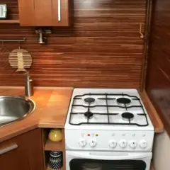 Kuchenny blat z drewnianym wykończeniem, zlewozmywak i kuchenka gazowa. Idealne miejsce do łączenia blatu kuchennego z innymi elementami.