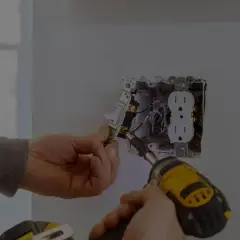 Elektryk montuje gniazdko i włącznik. Zastanawiasz się, ile kosztuje godzina pracy elektryka?