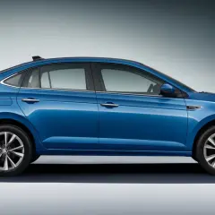 Niebieska Skoda Slavia z otwartym bagażnikiem, prezentująca elegancką sylwetkę i nowoczesny design.