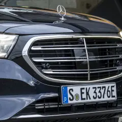 Dettaglio anteriore di un'auto di lusso con griglia cromata e fari a LED. La cromatura esterni risalta sulla carrozzeria scura.