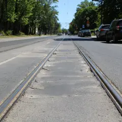 Torowisko tramwajowe na ulicy w Łodzi. Samochody stojące na poboczu sugerują utrudnienia w ruchu.