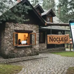Kamienny domek z tabliczką "NOCLEGI" i fakturą Airbnb na tablecie.