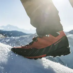 Pomarańczowe buty trekkingowe Mammut na śniegu, gotowe na wyprawę w Himalaje.