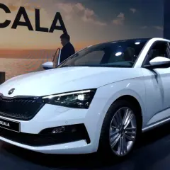 Biały skoda scala hatchback prezentuje się elegancko na tle miejskiego krajobrazu.