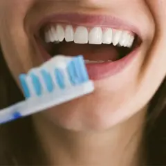 Sorriso smagliante con denti bianchi e spazzolino. Dedicare 10 minuti a lavarsi i denti garantisce un sorriso sano e luminoso.