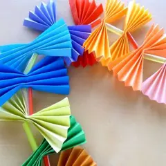 Kolorowy łańcuch choinkowy z papieru, wykonany techniką origami. Wesołe ozdoby w kształcie wachlarzy i kokardek.