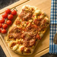 Pizza pepperoni z pomidorkami na desce. Zastanawiasz się, ile kalorii ma pizza 30 cm?
