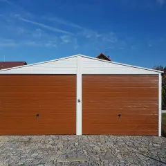 Nowy garaż blaszany z dwoma brązowymi bramami, gotowy na przyjęcie samochodów.