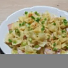 Szybki obiad z makaronem farfalle, szynką i szczypiorkiem, polany kremowym sosem.