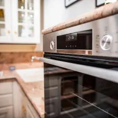 Forno moderno in acciaio inossidabile, con display digitale e manopole. Ideale per chi cerca come pulire il forno incrostato senza fatica.