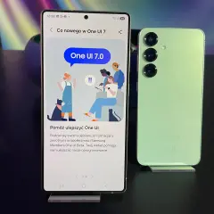 Jasny zielony Samsung obok telefonu z ekranem pokazującym "Co nowego w One UI 7.0".