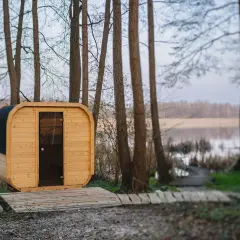 Drewniana sauna w lesie nad jeziorem.
