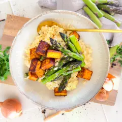 Cremiges Risotto mit grünem Spargel und knusprigen Tofuwürfeln, garniert mit frischer Petersilie. Ein köstliches Risotto mit Spargel.