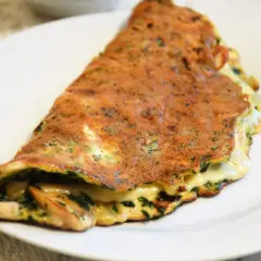 Złocisty omlet z serem i ziołami, idealny pomysł na szybką kolację.