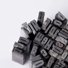 Metalowe czcionki do druku, przypominające o wymogach technicznych maszynopisu: czcionka, interlinia i marginesy.