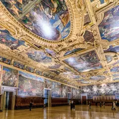 Intérieur grandiose du palais des Doges, plafonds peints et dorés racontant l'histoire de Venise. Des fresques monumentales ornent les murs et le plafond, témoins de la splendeur passée.