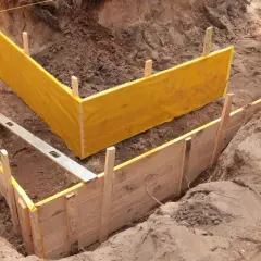 Wykonanie szalunku pod fundamenty z żółtą membraną i poziomicą.
