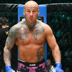 Artur Szpilka w ringu KSW, z tatuażami na klatce piersiowej i rękach.